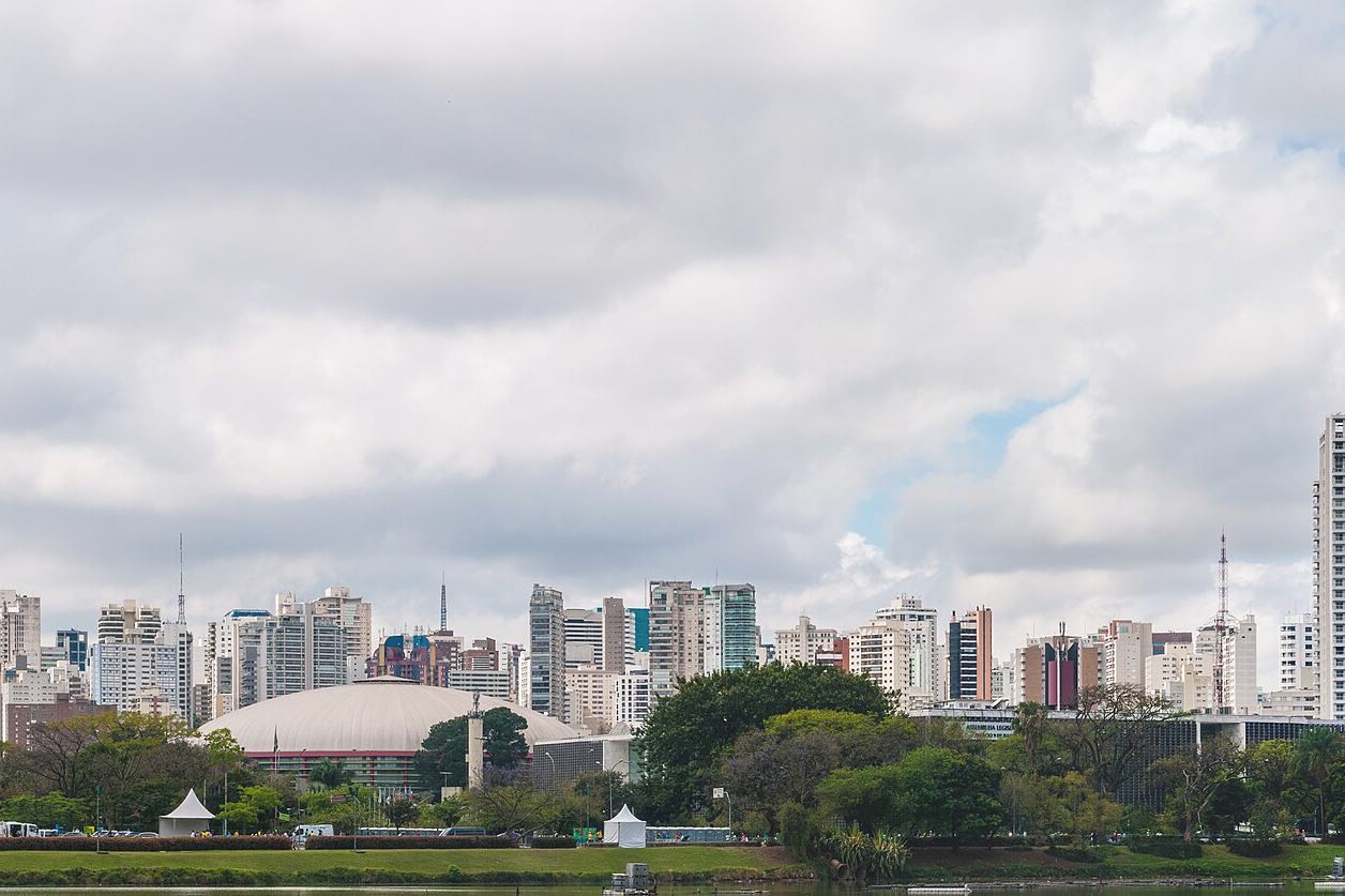 The skyline of São Paulo rising behind the trees of Ibirapuera Park.