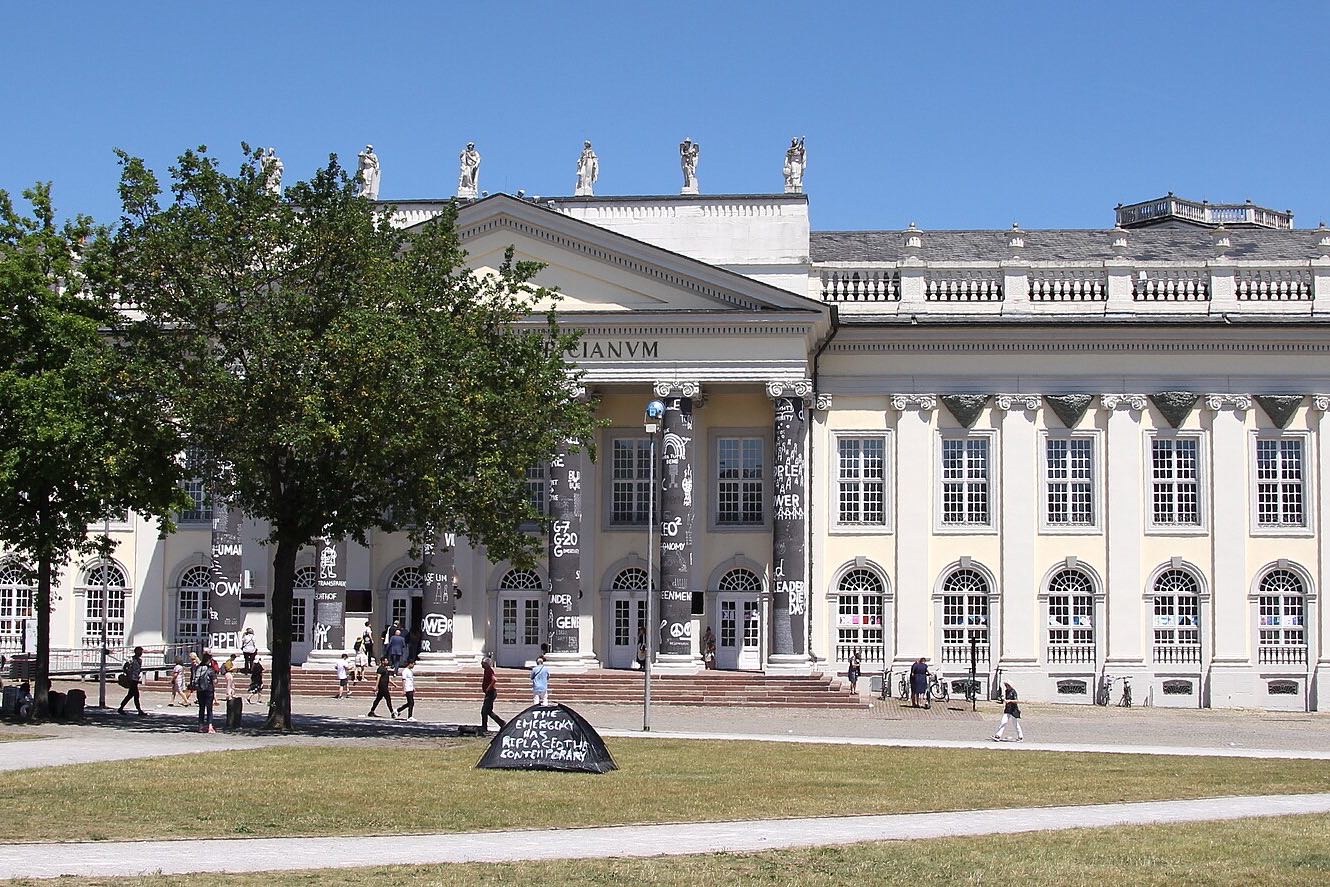 The Fridericianum in Kassel during documenta fifteen, in 2022, seen across the lawn of the Friedrichsplatz.