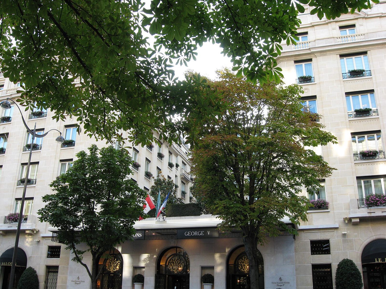 The Four Seasons Hotel George V behind the trees of the avenue.