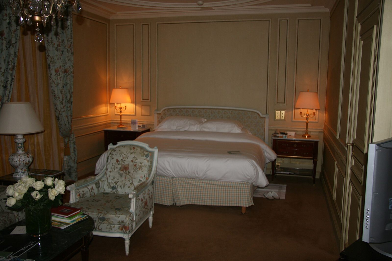 A bedroom at Le Meurice, panelled and furnished in the style of Louis XVI, with a chandelier.