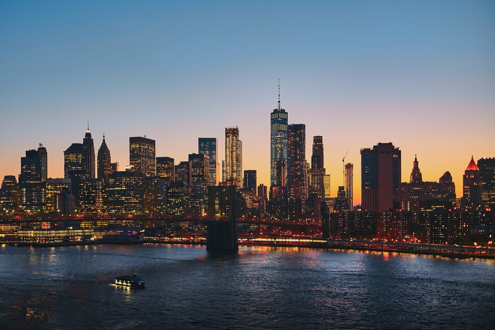 The Brooklyn Bridge and the Manhattan skyline at dusk.