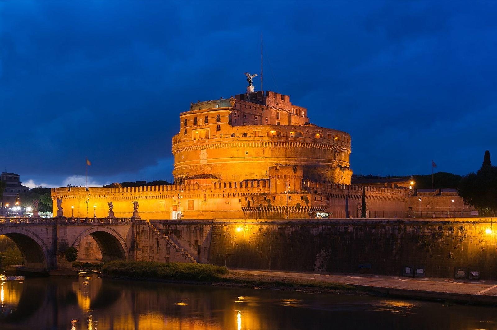 Castel Sant'Angelo lit at dusk above the Tiber.